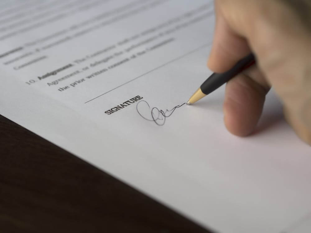 A person signing a document in front of a mobile notary